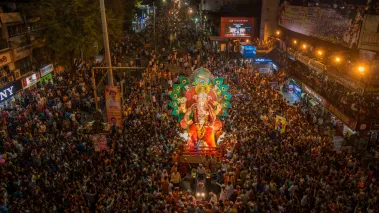 Crowd carries a statue of the Hindu god Ganesha for immersion in water during a festival.
