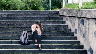 Sad college student at school on steps