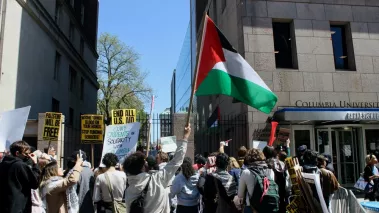 Pro-Palestinian protesters holding flags and signs outside Columbia University