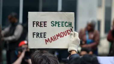 Protester holding a sign that reads Free Speech Free Mahmoud March 12 2025