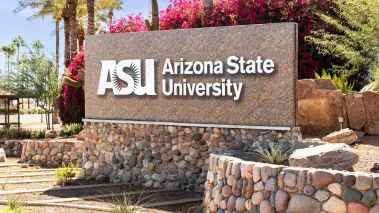 Arizona State University entrance sign in Tempe surrounded by sand, stone, and cactus
