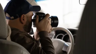 Private investigator taking photos in his car