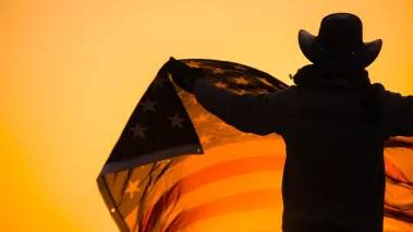 Texan in cowboy hat holding US flag