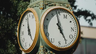 Classic campus clock at Sam Houston State University in Huntsville, Texas, captured on a sunny afternoon, surrounded by academic charm