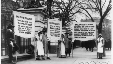Protesters dressed as pilgrims carry signs calling for amnesty for political prisoners standing in front of the White House, circa 1918.