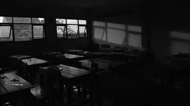 A darkened classroom with open windows