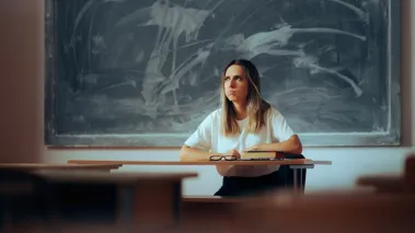 Frustrated schoolteacher sitting at her desk