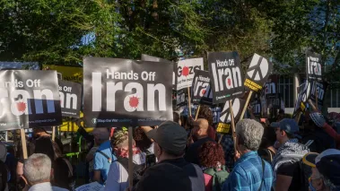Protesters gather with Palestinian flags and "Hands Off Iran" signs during a demonstration near the US Embassy in London.