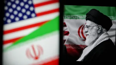 Iranian Supreme Leader Ayatollah Ali Khamenei next to Iranian and US flags displayed on screens