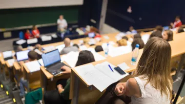 Students sit in lecture hall as professor speaks