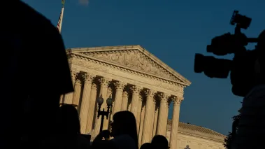 Supreme Court Building in Washington DC with TV camera black Silhouettes in foreground