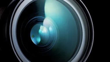 Lens of a campera on black background (Image via Shutterstock.com)