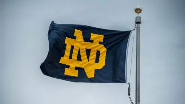 University of Notre Dame logo flag blue and gold on a flag pole in South Bend Indiana (Image via Shutterstock.com)