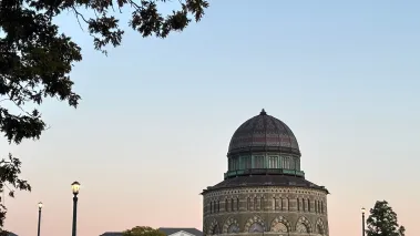View of Union College campus with the Nott Building at dusk framed by tree branches (Image via Shutterstock.com)