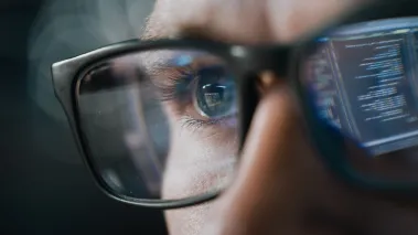 reflection of AI output in man's glasses as he reads