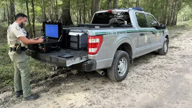 An FWC officer readies a drone at the back of his truck