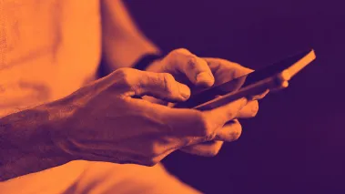 image of a woman's hands as she posts on social media on her phone, in duotone
