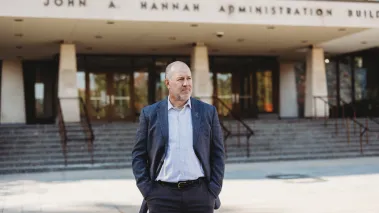 FIRE plaintiff Michael Balow standing in front of the John Hannah Administration Building at Michigan State University