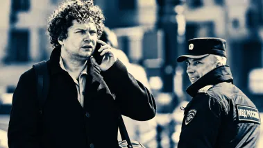 Man on phone in Moscow walks past police officer