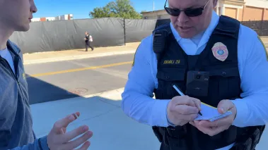 Officer Taking Notes on Campus Street