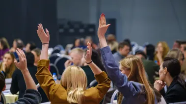 female students raise hands in class