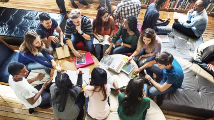students reading on the floor of a college campus