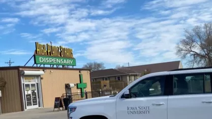 Iowa State University car in front of dispensary.