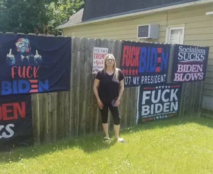 Andrea Dick stands before the banners and flags that led the city of Roselle Park to charge her with obscenity