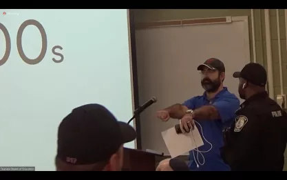 Protestor confronted by police at the Oct. 18, 2023 Teaneck School Board meeting