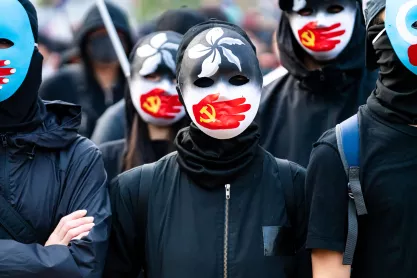 Protestors wear masks with Communist Party of China flag on a hand over their mouths