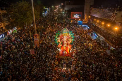 Crowd carries a statue of the Hindu god Ganesha for immersion in water during a festival.
