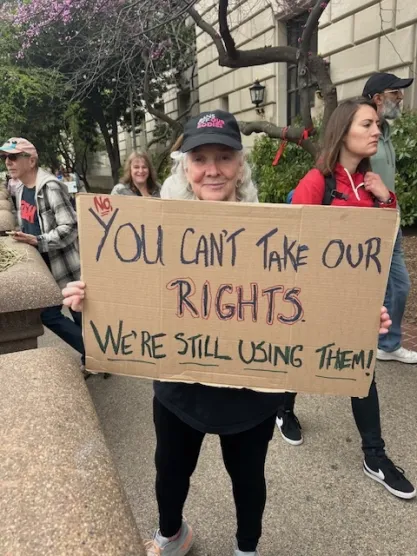 Protestor at "Hands Off" rally in Washington DC on April 5, 2025 holding a sign: "You can't take our rights. We're still using them."