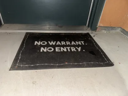 UC Irvine student doormat saying "No Warrant. No Entry."