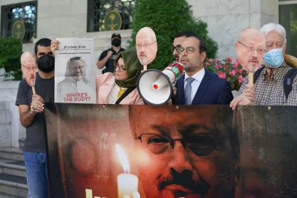 Jamal Khashoggi's fiancé Hatice Cengiz looks at his photo as Nihad Awad of CAIR speaks about the murder during a demonstration at the Saudi Embassy, Washington DC, October 2021