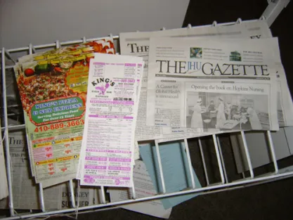 These photographs from May 20, 2006, show a newspaper distribution rack in Johns Hopkins University’s Wolman Hall, a dorm on campus, that displays copies of the Hopkins Donkey, a Democratic student publication, along with several advertisements from a pizza shop.