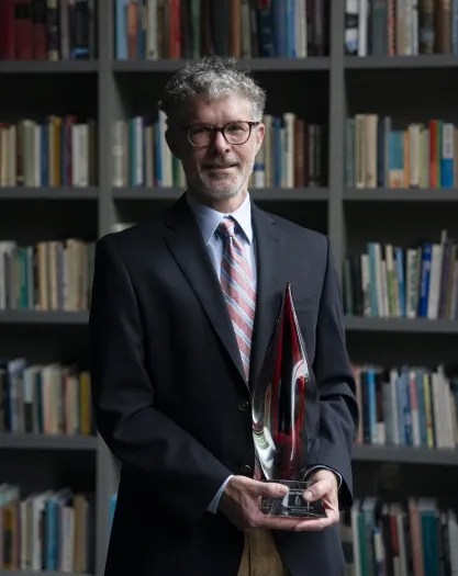 Image of Charlie Kurth holding FIRE's Berkson Award
