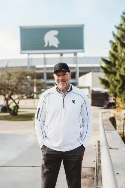 FIRE plaintiff Michael Balow standing in front of the MSU stadium