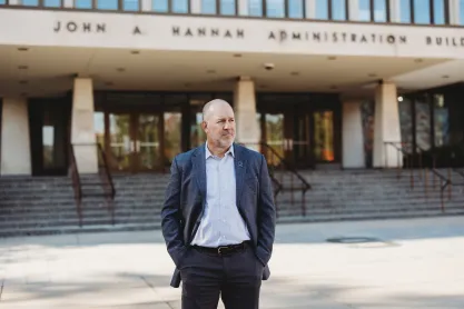 FIRE plaintiff Michael Balow standing in front of the John Hannah Administration Building at Michigan State University
