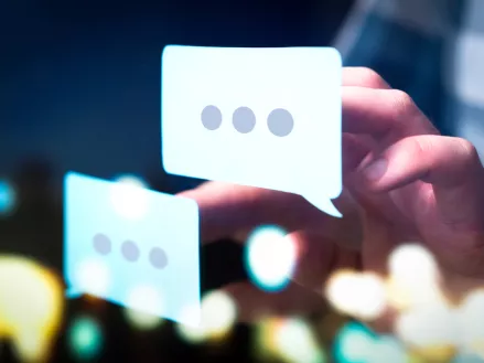 Business man or social media consultant holding speech bubbles in futuristic modern abstract space.
