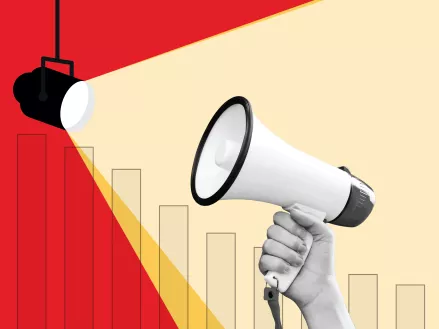 Person holding a megaphone up to a spotlight