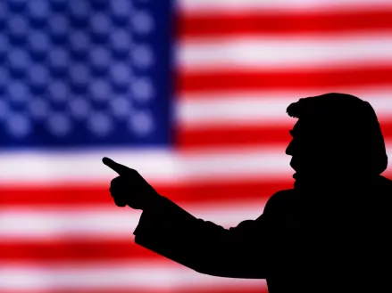 silhouette of Donald Trump against the background of the American flag.