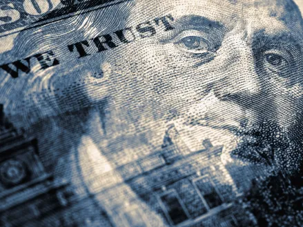 Hundred dollar bill with portrait of Benjamin Franklin in focus Blue tinted illustration