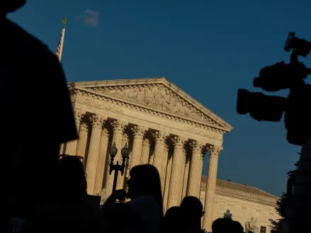 Supreme Court Building in Washington DC with TV camera black Silhouettes in foreground