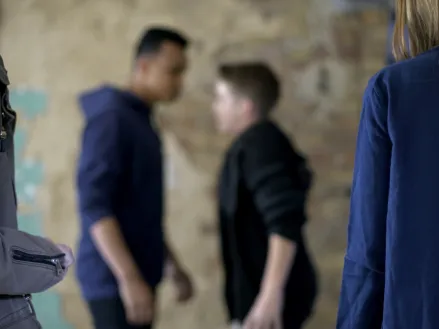 Teenage boys fighting true threats with blurred background (Image via Shutterstock.com)
