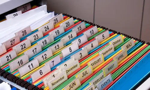 Open file cabinet with folders and many colored tabs
