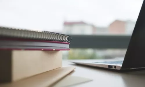 open laptop computer and notebooks on a table
