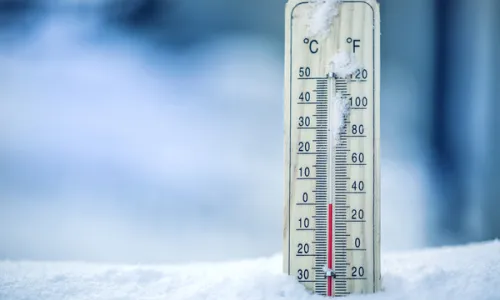 A thermometer in snow, reading zero celsius.