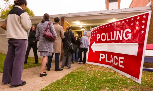 Voting polling place sign and people lined up on presidential election day 