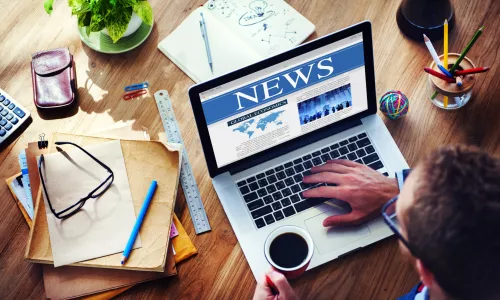 Person writing on a computer at a desk
