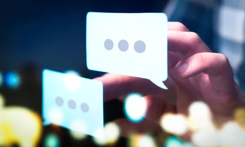 Business man or social media consultant holding speech bubbles in futuristic modern abstract space.